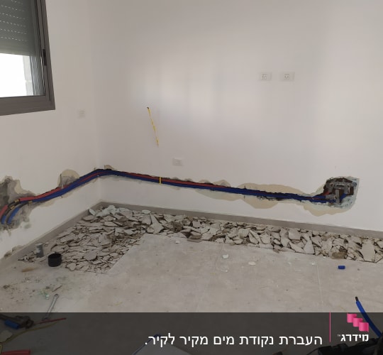 קירות פתוחים עם צינורות צבעוניים וכלי עבודה על הרצפה